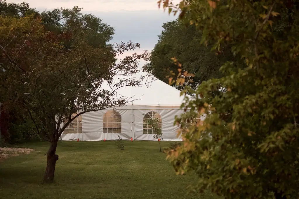White event tent set up among trees